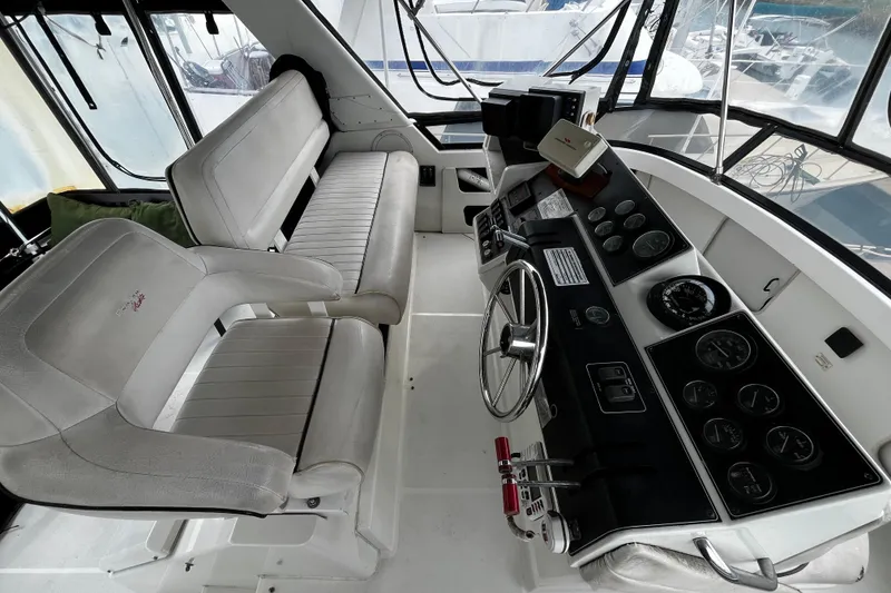 Slide: The Image of 1991 Carver 33 Aft Cabin Motor Yacht helm with gauges and steering wheel. - 12