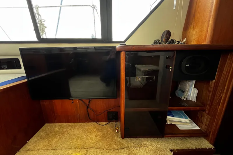 Slide: The Image of 1991 Carver 33 Aft Cabin Motor Yacht helm with wooden steering wheel and navigation equipment. - 30