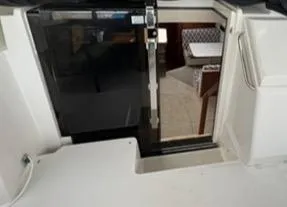 Slide: The Image of 1991 Carver 33 Aft Cabin Motor Yacht interior with green seating and wooden table. - 9