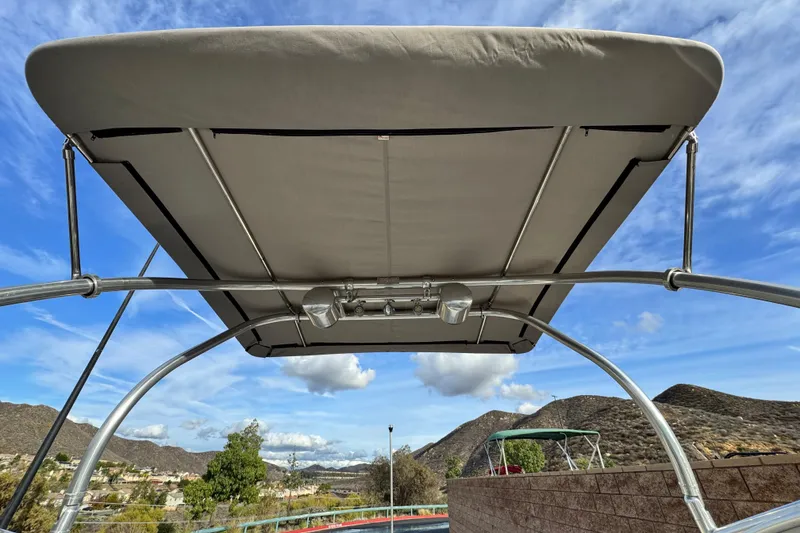 Slide: The Image of Bimini top of 2001 Sea Ray 240 Sundeck against a scenic mountain backdrop. - 13