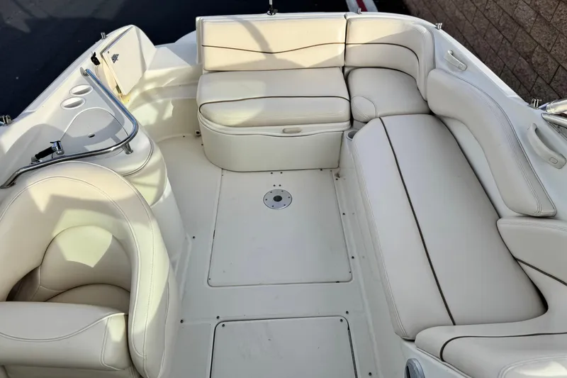 Slide: The Image of 2001 Sea Ray 240 Sundeck interior with white leather seating and cup holders. - 22