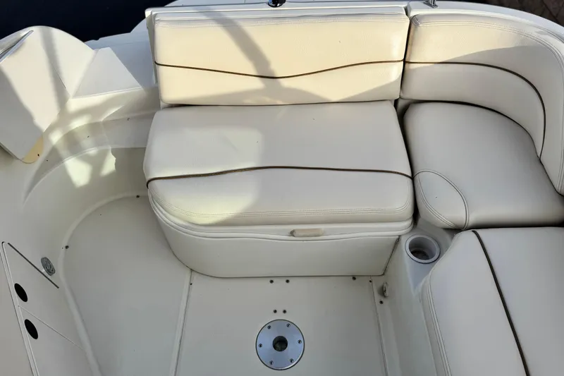 Slide: The Image of 2001 Sea Ray 240 Sundeck boat interior with white cushioned seating. - 23