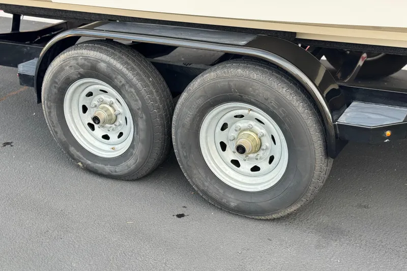 Slide: The Image of Trailer wheels for 2001 Sea Ray 240 Sundeck boat on asphalt surface. - 37