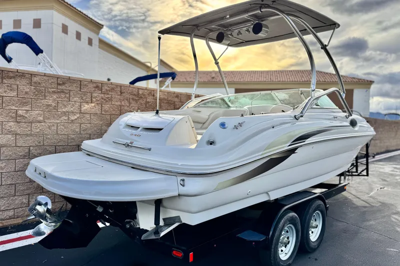 Slide: The Image of 2001 Sea Ray 240 Sundeck boat on trailer, parked outdoors under a cloudy sky. - 5