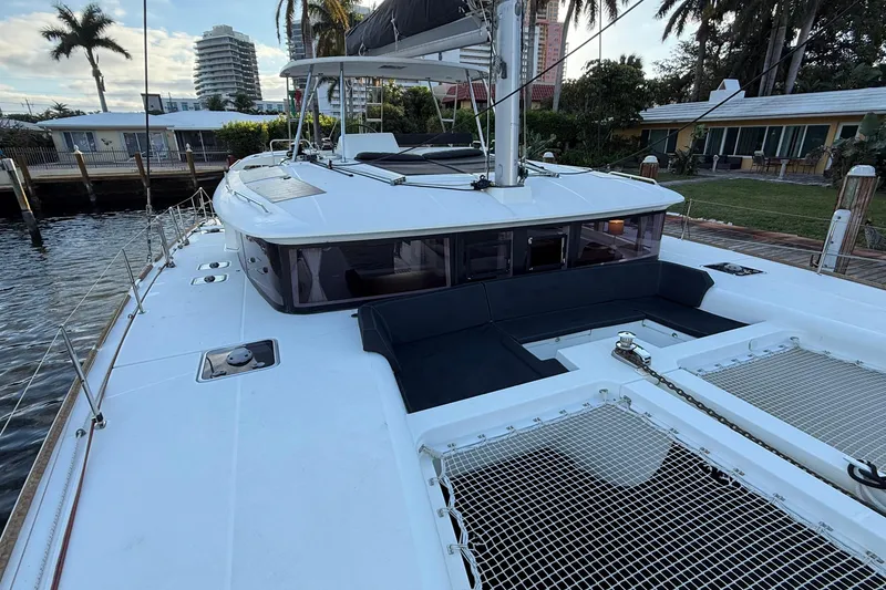 Slide: The Image of 2019 Lagoon 450 catamaran docked, featuring spacious deck and modern design. - 2