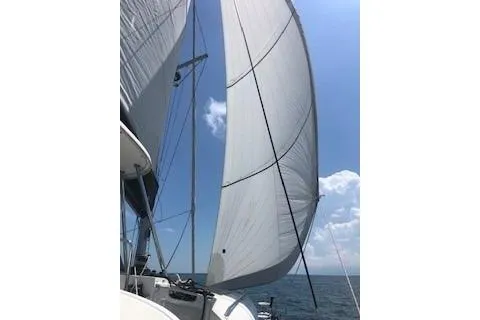 Slide: The Image of 2019 Lagoon 450 sailboat with sails unfurled against a clear blue sky. - 30