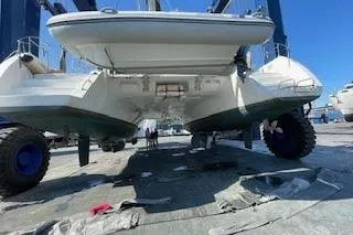 Slide: The Image of 2019 Lagoon 450 catamaran on a lift, showcasing its hull and undercarriage. - 40