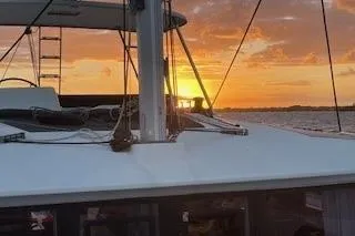 Slide: The Image of Lagoon 450 catamaran sailing at sunset, 2019 model, with vibrant sky and ocean view. - 49