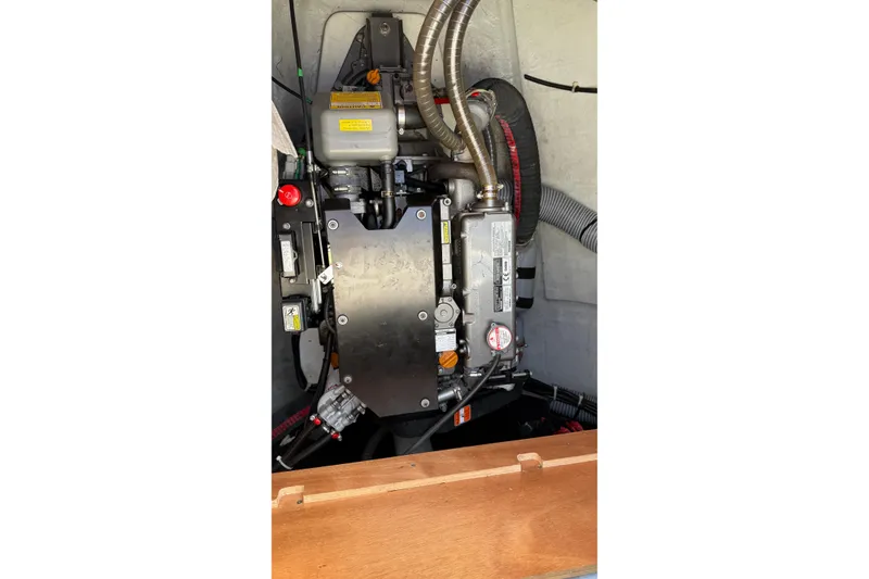 Slide: The Image of Engine compartment of a 2019 Lagoon 450 catamaran, showcasing mechanical components and hoses. - 52