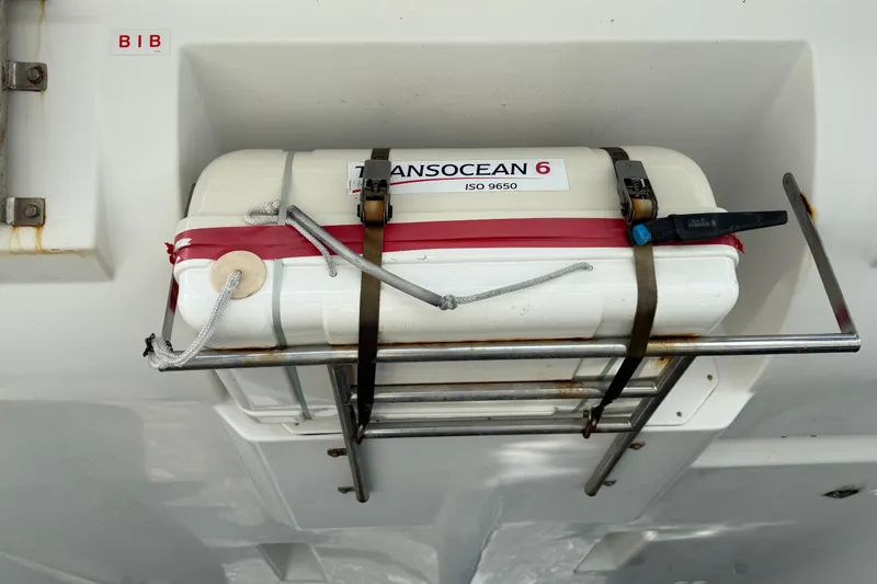 Slide: The Image of Life raft on 2019 Lagoon 450 catamaran, secured with straps and labeled "Transocean 6." - 61