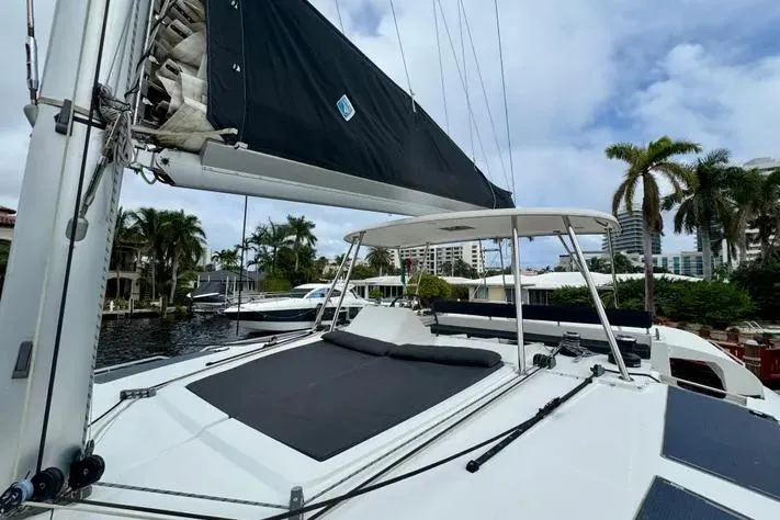 Slide: The Image of 2019 Lagoon 450 catamaran docked, featuring sleek design and spacious deck under a cloudy sky. - 7