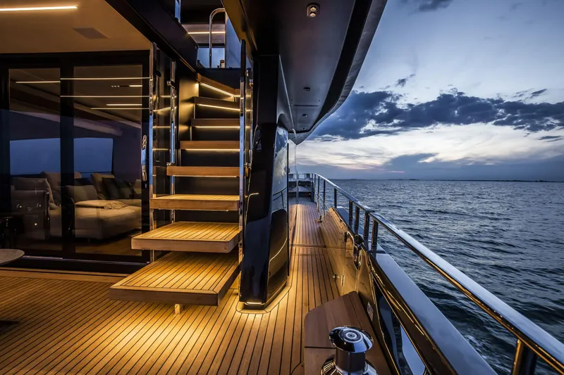 Slide: The Image of Luxurious 2026 Cranchi Sessantasette 67 yacht deck at sunset, featuring elegant lighting and ocean views. - 18
