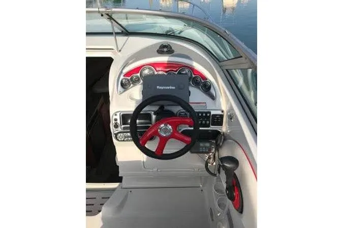 Slide: The Image of 2004 Crownline 270 CR boat dashboard with red steering wheel and navigation equipment. - 5