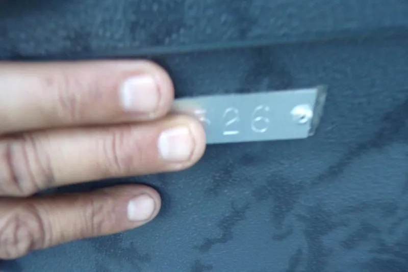 Slide: The Image of Hand holding a metal plate with "526" on Xpress X18DB, 2026 model. - 12