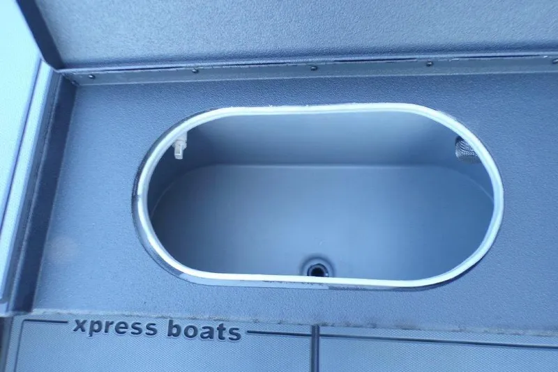 Slide: The Image of 2026 Xpress X18DB boat storage compartment with open lid, showcasing interior space. - 14