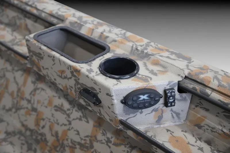 Slide: The Image of Manufacturer Provided Image: 2026 Xpress X18DB boat interior with camouflage design, featuring control panel and cup holder. - 32
