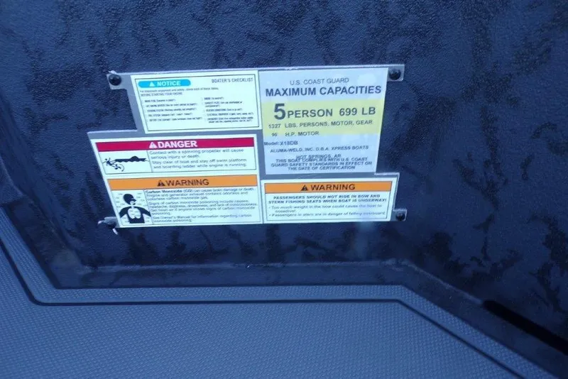 Slide: The Image of Safety and capacity labels on 2026 Xpress X18DB boat, maximum 5 persons, 699 lbs. - 7