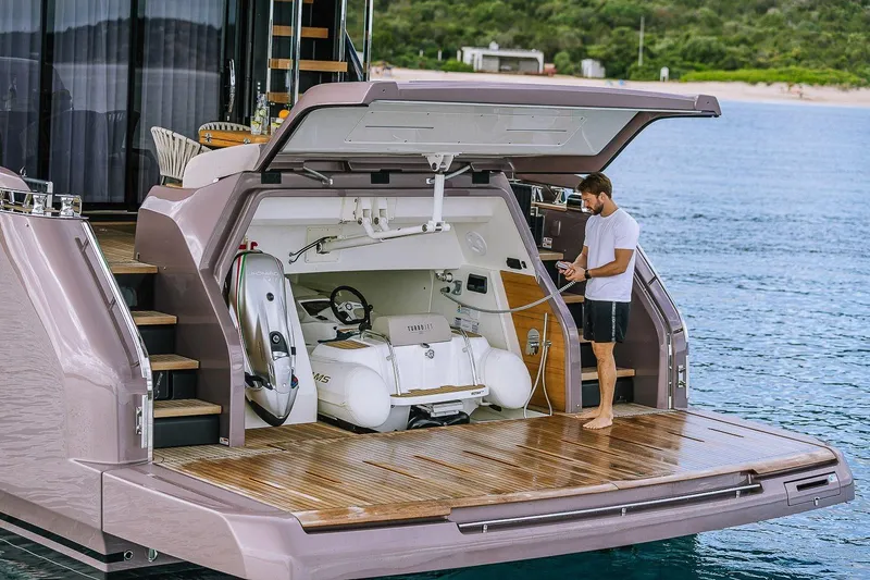 Slide: The Image of 2026 Cranchi Sessantadue 62 yacht with open garage, man standing on deck. - 37