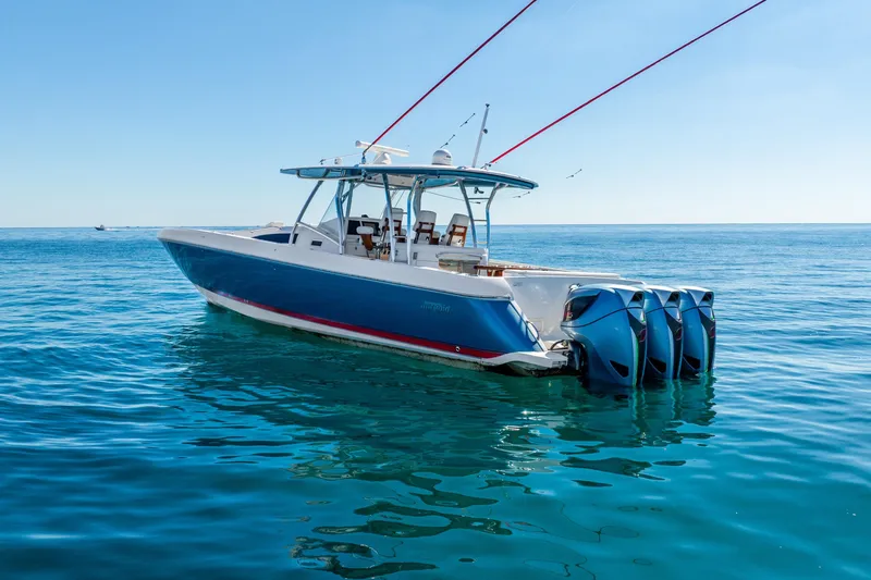 Slide: The Image of 2015 Intrepid 475 Panacea boat with four engines on calm blue water. - 2