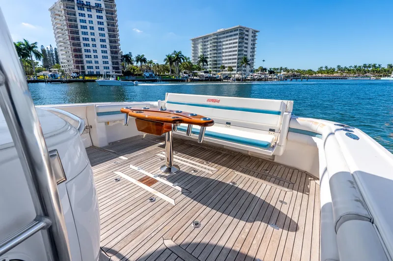 Slide: The Image of 2015 Intrepid 475 Panacea yacht deck with seating, overlooking waterfront buildings. - 24