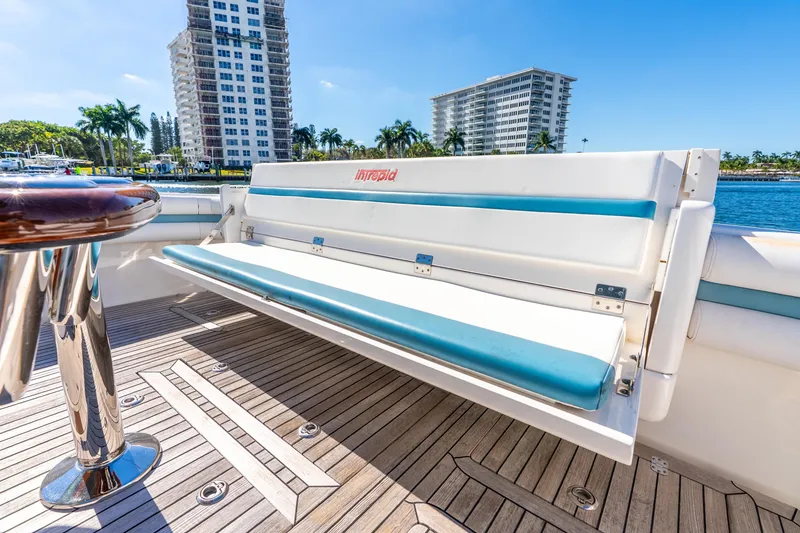Slide: The Image of 2015 Intrepid 475 Panacea boat interior with cushioned seating and wooden deck. - 25