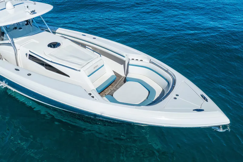 Slide: The Image of 2015 Intrepid 475 Panacea boat on clear blue water, showcasing sleek design and spacious seating. - 8