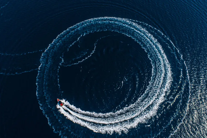 Slide: The Image of Aerial view of 2026 Cranchi A46 Luxury Tender creating circular wake on deep blue water. - 48