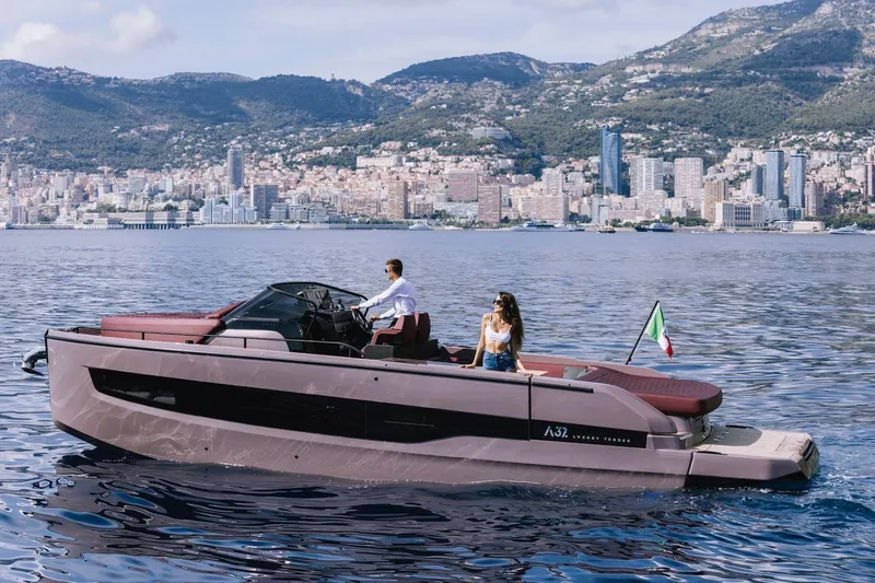 Slide: The Image of 2026 Cranchi A32 Luxury Tender cruising near scenic coastal cityscape. - 2