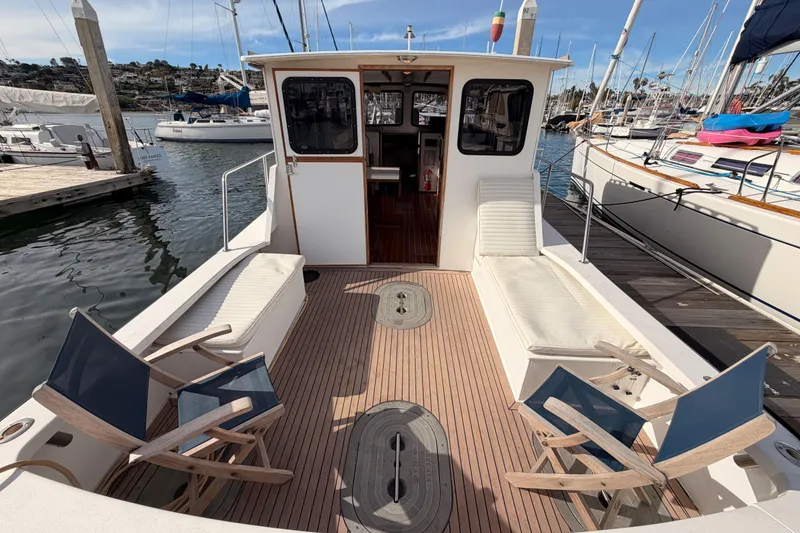 Slide: The Image of 2002 Eastern Downeast 35 boat deck with seating and chairs at marina. - 10