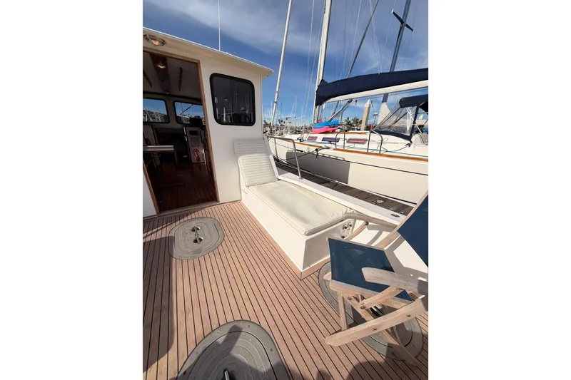 Slide: The Image of 2002 Eastern Downeast 35 boat deck with seating and wooden flooring. - 12