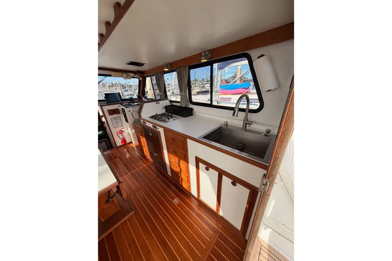 Slide: The Image of Interior of 2002 Eastern Downeast 35 boat with wooden flooring and kitchen amenities. - 25