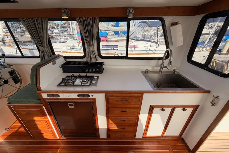 Slide: The Image of Interior of a 2002 Eastern Downeast 35 boat featuring a compact kitchen with stove and sink. - 26