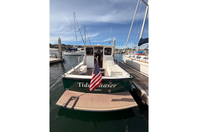 Slide: The Image of 2002 Eastern Downeast 35 boat docked with American flag, clear sky background. - 4