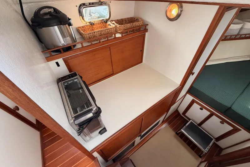 Slide: The Image of Compact galley in 2002 Eastern Downeast 35 boat with appliances and wooden cabinetry. - 42