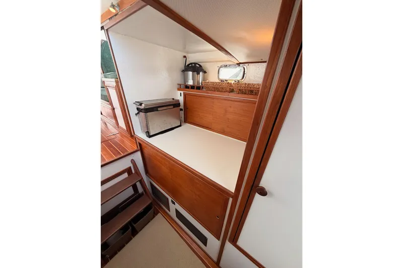 Slide: The Image of 2002 Eastern Downeast 35 boat interior with wooden cabinetry and compact kitchen area. - 43
