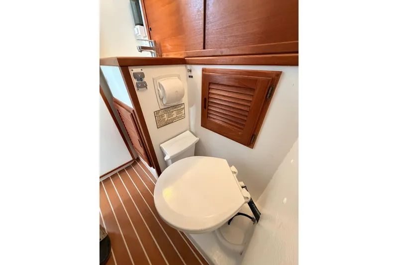 Slide: The Image of 2002 Eastern Downeast 35 boat bathroom with wooden cabinetry and marine toilet. - 45