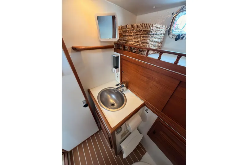 Slide: The Image of 2002 Eastern Downeast 35 boat bathroom with wooden cabinetry and stainless steel sink. - 46