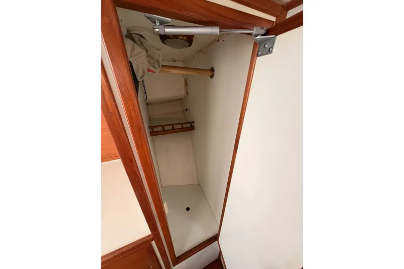 Slide: The Image of Interior closet of 2002 Eastern Downeast 35 boat with wooden trim and storage space. - 48