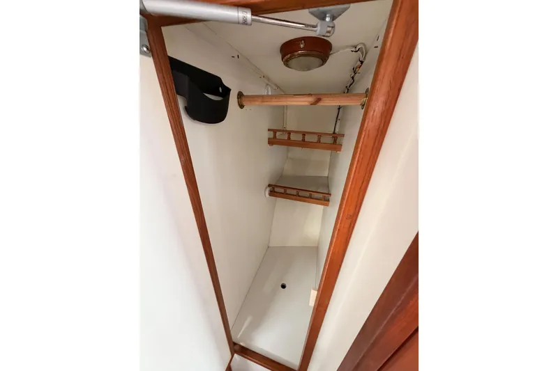 Slide: The Image of Interior closet of 2002 Eastern Downeast 35 boat with wooden shelves and light fixture. - 49