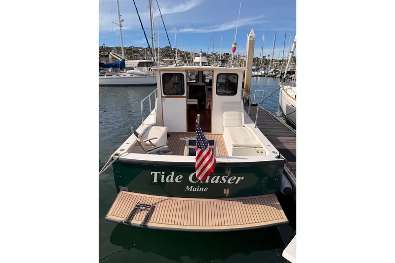 Slide: The Image of 2002 Eastern Downeast 35 boat docked, displaying American flag and "Tide Chaser" name. - 5