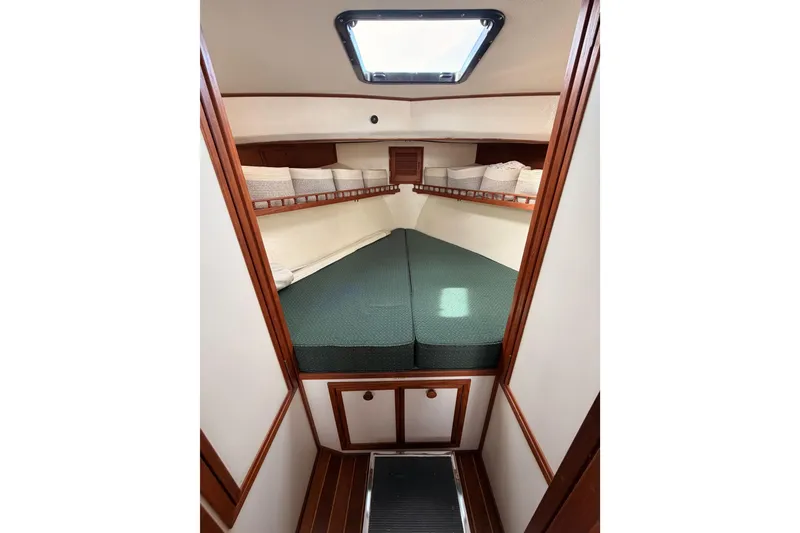 Slide: The Image of Cozy cabin interior of 2002 Eastern Downeast 35 boat with green bedding and wooden accents. - 50