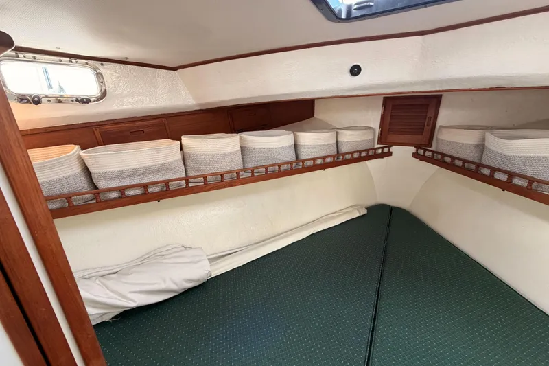 Slide: The Image of Cozy cabin interior of 2002 Eastern Downeast 35 boat with storage baskets and green bedding. - 51