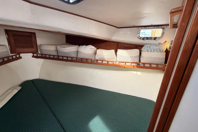 Slide: The Image of Cozy cabin interior of 2002 Eastern Downeast 35 boat with storage baskets and green bedding. - 52