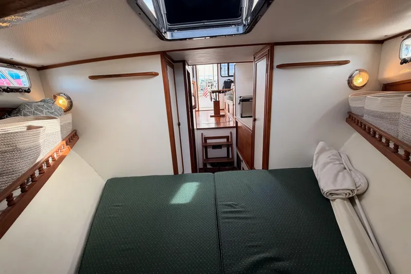 Slide: The Image of Interior of 2002 Eastern Downeast 35 boat with cozy sleeping area and wooden accents. - 55