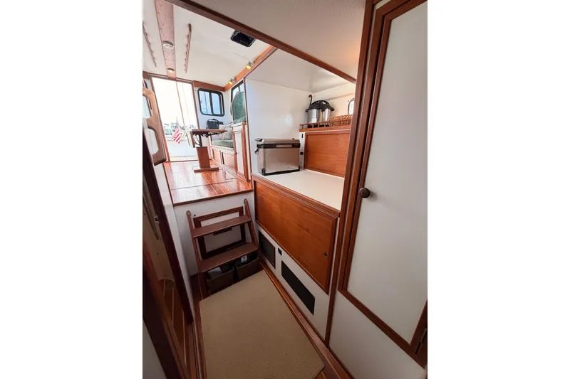 Slide: The Image of Interior of 2002 Eastern Downeast 35 boat, featuring wooden cabinetry and compact kitchen area. - 56