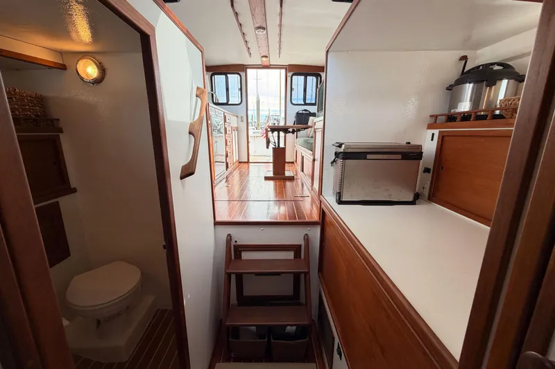 Slide: The Image of Interior of 2002 Eastern Downeast 35 boat, featuring a compact kitchen and bathroom. - 57