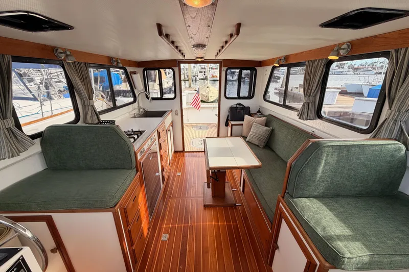 Slide: The Image of Interior of a 2002 Eastern Downeast 35 boat with green seating and wooden flooring. - 59