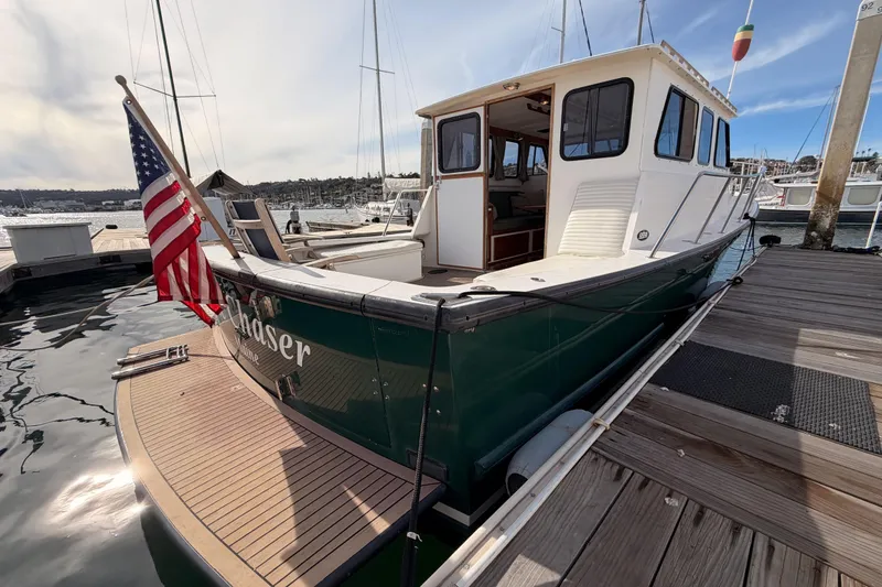 Slide: The Image of 2002 Eastern Downeast 35 boat docked, displaying American flag, with marina background. - 6