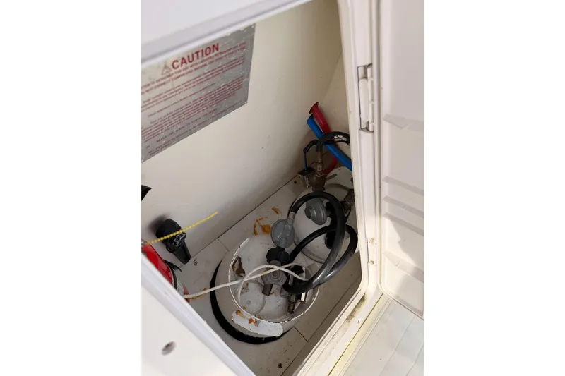 Slide: The Image of Storage compartment of a 2002 Eastern Downeast 35 boat with hoses and caution sign. - 63