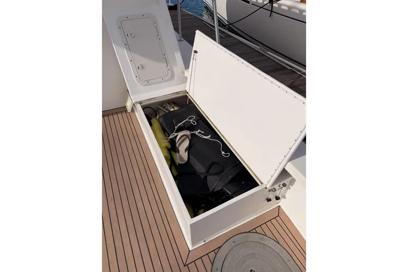 Slide: The Image of Open storage compartment on 2002 Eastern Downeast 35 boat deck, containing various items. - 64
